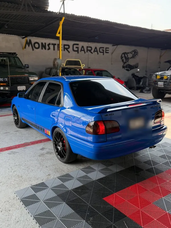 Toyota Corolla azul: trasera después, en Monster Garage Vzla, Valencia