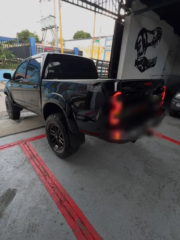 Toyota Hilux gris a negro: trasera después, en Monster Garage Vzla, Valencia