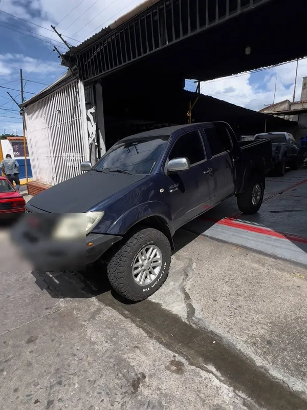 Toyota Hilux gris a negro: lateral antes, en Monster Garage Vzla